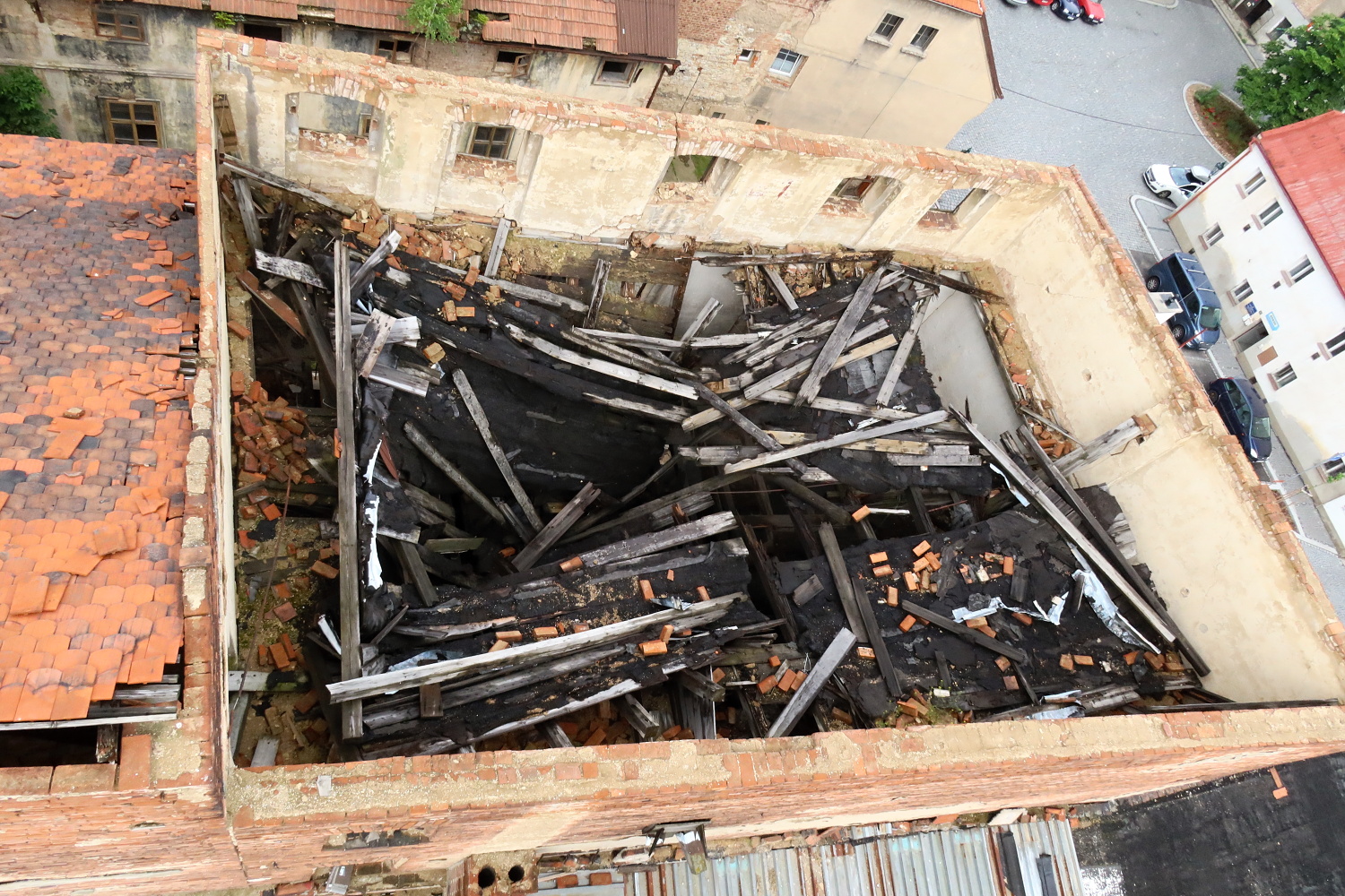 Riziková demolice nejvyššího patra severní budovy bývalé sušárny chmele v Žatci, navazující na obydlenou část